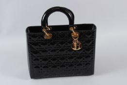 A CHRISTIAN DIOR BLACK PATENT HANDBAG. 31cms long, with dust bag. Unused. Purchased new on 13/12/