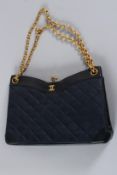 A VINTAGE CHANEL BLUE LEATHER PADDED BAG with gilt double C and gilt strap. 23cms long, with dust