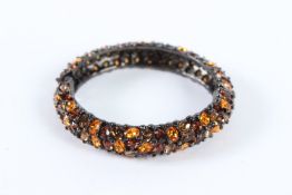 A MULTI-COLOURED STONE BANGLE. 8cms.