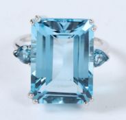 A SILVER LARGE EMERALD CUT BLUE TOPAZ RING.