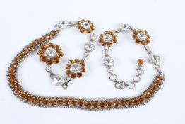 A LARGE DECORATIVE NECKLACE set with large diamante and amber stones. 90cms long.
