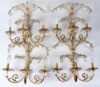 A SET OF FOUR ORMOLU THREE BRANCH WALL APPLIQUES, with cut glass drops. 36cms wide x 38cms high.