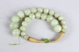 A GREEN JADE BEAD NECKLACE.