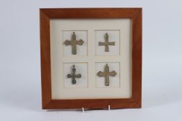 FOUR EARLY METAL CROSSES in a frame.