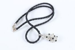 A DIAMANTE PENDANT on a rope.