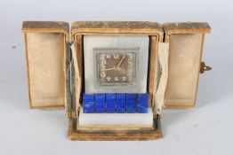 A HARRODS OF LONDON ONYX AND LAPIS TRAVELLING CLOCK in a folding leather case. 10cms high.