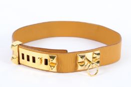 A HERMES LEATHER AND BRASS BELT. 86cms long x 5cms wide, in original box.
