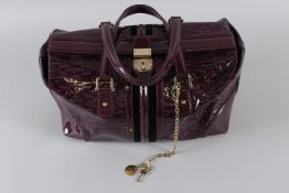 A LARGE GUCCI BURGUNDY PATENT BAG with chrome catch and plain handle. No. 150335 001013. 36cms long,