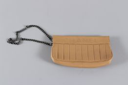 A CHANEL TAN LEATHER PURSE with zip and long gilt chain. 19cms long, with dust cover. Sold with