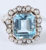 A SILVER BLUE TOPAZ AND PEARL RING.