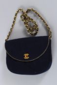 A CHANEL BLUE FABRIC BAG with gilt double C. gilt and leather strap. 20cms long, with dust cover.