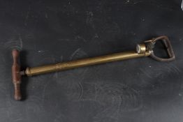 A BRASS PUMP, The Rotex Company, with wooden handle. 60cms high.