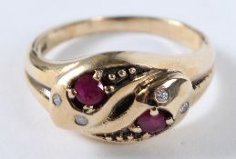 A 9CT GOLD TWO RUBY AND DIAMOND SET DOUBLE SNAKE HEAD RING.