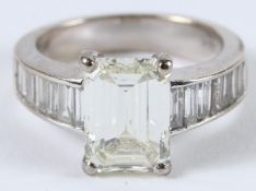 A SUPERB EMERALD CUT DIAMOND RING with baguette shoulders. Diamond 3ct. Colour K. Clarity VS2.