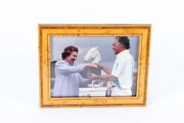 A PHOTO OF QUEEN ELIZABETH presenting a Polo trophy, in a walnut frame. 17cms x 23cms.