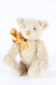 A STEIFF BEAR with yellow ribbon. 28cms high.