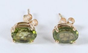 A PAIR OF 9CT GOLD OVAL PERIDOT STUD EARRINGS.