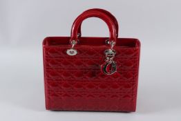 A CHRISTIAN DIOR RED PATENT LEATHER HANDBAG. 31cms long, with dust bag. Unused. Sold with