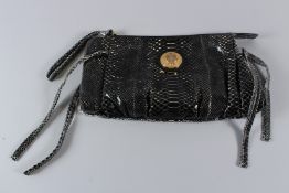 A GUCCI SNAKESKIN BAG with zip and four handles, with circular gilt GUCCI crest. 38cms long, with