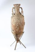 A LARGE ROMAN OR GREEK AMPHORA with two handles, in a metal stand. 92cms high.