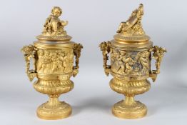 A GOOD PAIR OF CUPID URNS AND COVERS symbolising harvest of grapes. 34cms high.