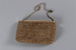 AN ESCADA GOLD STUDDED EVENING BAG with gilt metal strap. 19cms long, with dust cover.