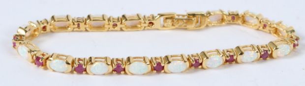 A SILVER AND 18CT GOLD PLATED OPAL AND RUBY BRACELET.