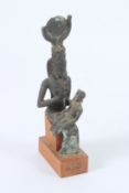 AN ANCIENT BRONZE STATUE of the Egyptian goddess ISIS nursing her son, on a wooden base. 13cms
