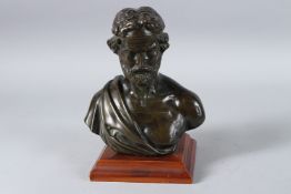 A MID 19TH CENTURY BRONZE ROMAN BUST OF A MAN. 7ins high, on a wooden base.