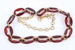 A DECORATIVE AMBER AND GILT METAL CHAIN. 100cms long.