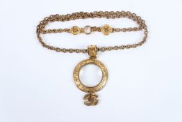 A GOOD CHANEL GILT METAL MONOCLE on a chain link.