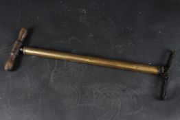 A BRASS PUMP with wooden handle. 58cms high.