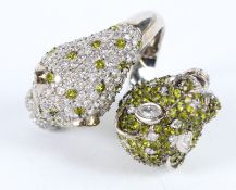 A SILVER RING set with two diamante leopard heads.