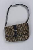 A VINTAGE CHRISTIAN DIOR CLOTH AND LEATHER SADDLEBAG with long leather handle, with CD clasp. 30ins