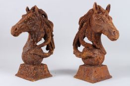 A PAIR OF CAST IRON HORSE'S HEADS on spheres. 17ins high