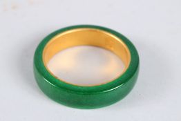 A CHINESE GOLD LINED JADE BANGLE. 2.5ins diameter
