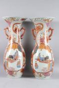 A GOOD PAIR OF TALL IMARI VASES with handles, the body painted with panels of figures and dragons.