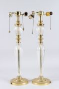 A PAIR OF GLASS AND BRASS LAMPS on circular bases. 23ins high