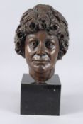 A LARGE BRONZE FEMALE HEAD on a marble base. 12ins high