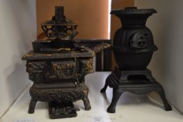 Two miniature cast iron cooking ranges.