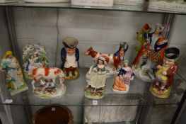 A good collection of Staffordshire and Pearl ware figures to include figural spill vases and toby