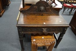 A Victorian oak side table with carved decoration.