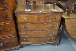 A reproduction mahogany serpentine fronted four drawer chest.