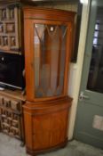 A reproduction standing corner cabinet.