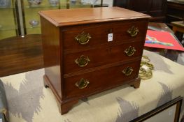 A miniature Georgian style three drawer chest opening to reveal an early radio.