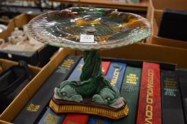 A majolica tazza modelled as a shell being held aloft by three dolphins.