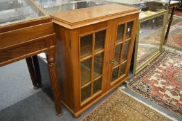 A small oak two door display cabinet or bookcase.