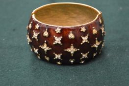 A Kenneth Lane decorative red enamel bangle.