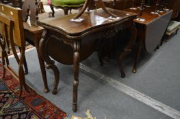 A Victorian style mahogany serpentine shaped fold-over tea table on cabriole legs.