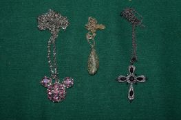 A bear necklace, cross and chain and a pendant and chain.